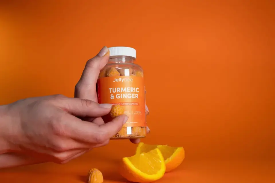 A hand holding a dog joint supplement bottle while reading the label