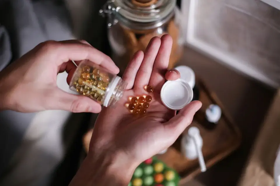 A hand holding a dog supplement bottle to read the ingredient label