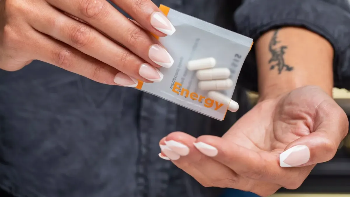 A hand holding a dog supplement bottle up to read the ingredient label