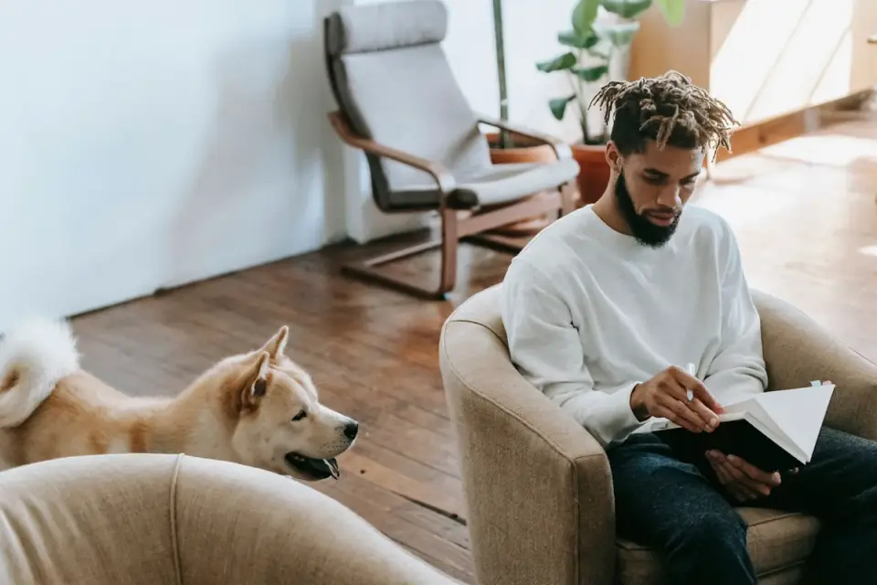 A veterinarian reading a supplement label next to a seated dog